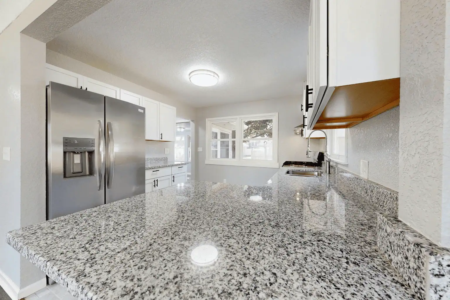 Comparison of granite and engineered quartz kitchen countertops in a modern Houston kitchen remodel by Modern Home Improvement and Remodeling